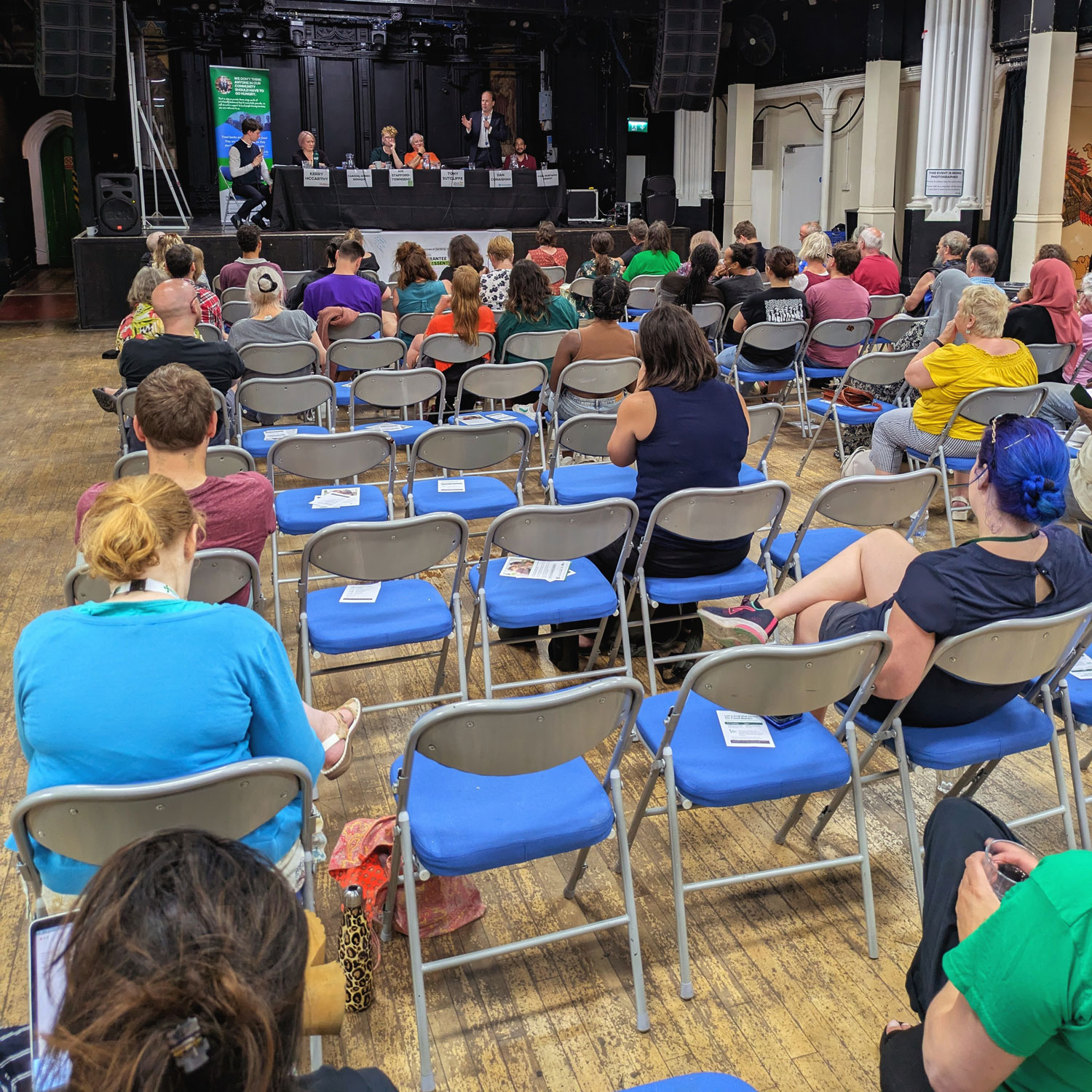The crowd sitting and listening to candidates speak